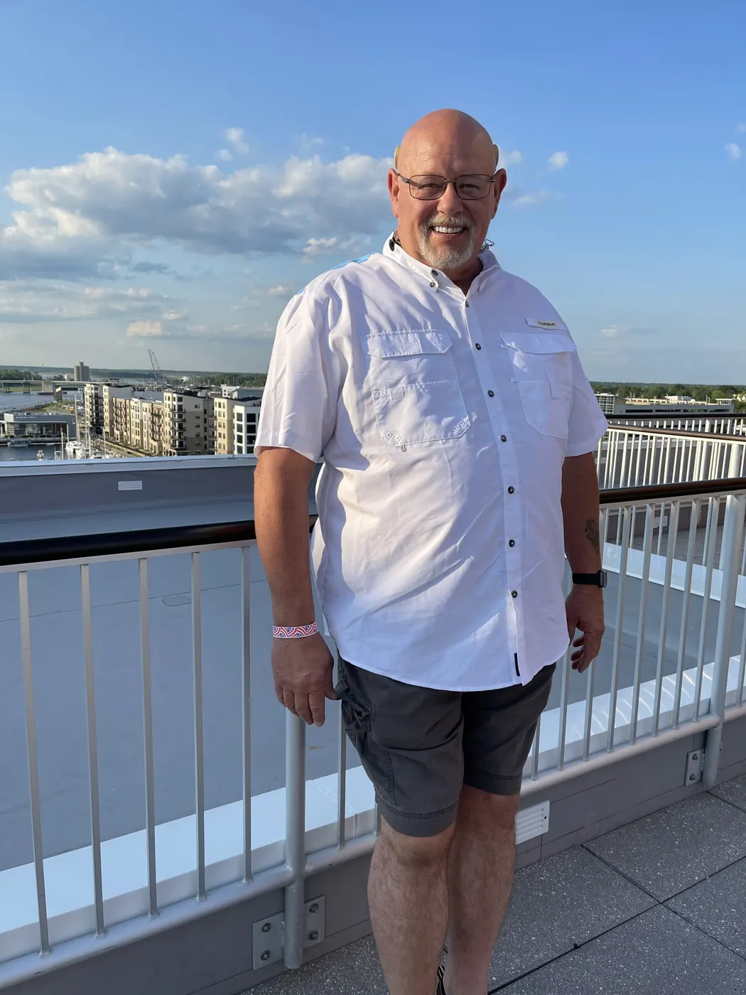 Brian Fredrick, founder of ABC Plumbing Heat and Air, standing on a deck in a white shirt
