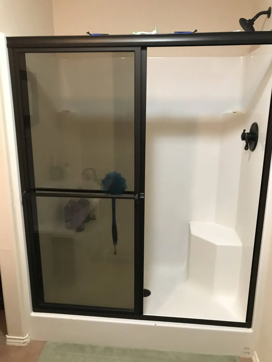 A new white shower insert with a black-framed glass door
