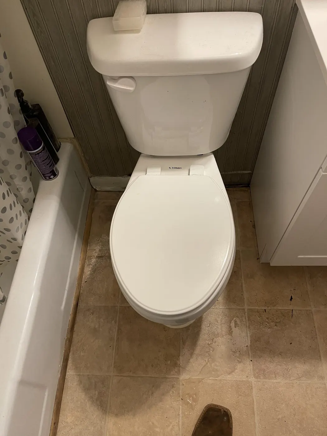 A new white toilet installed in a small bathroom